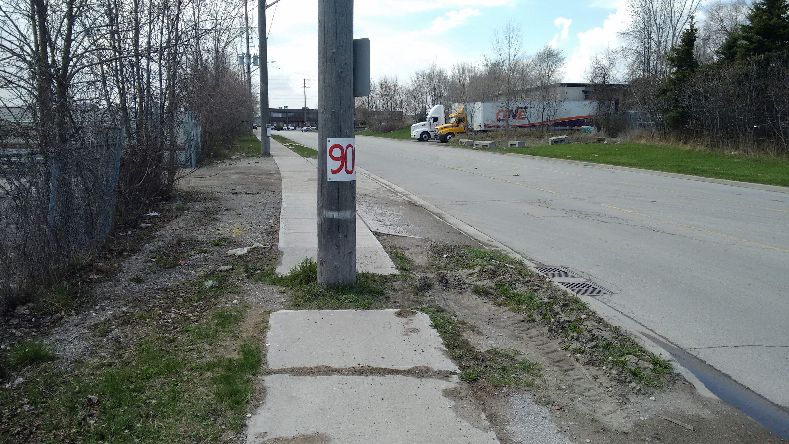 sidewalk with a telephone pole obtrusively blocking the way